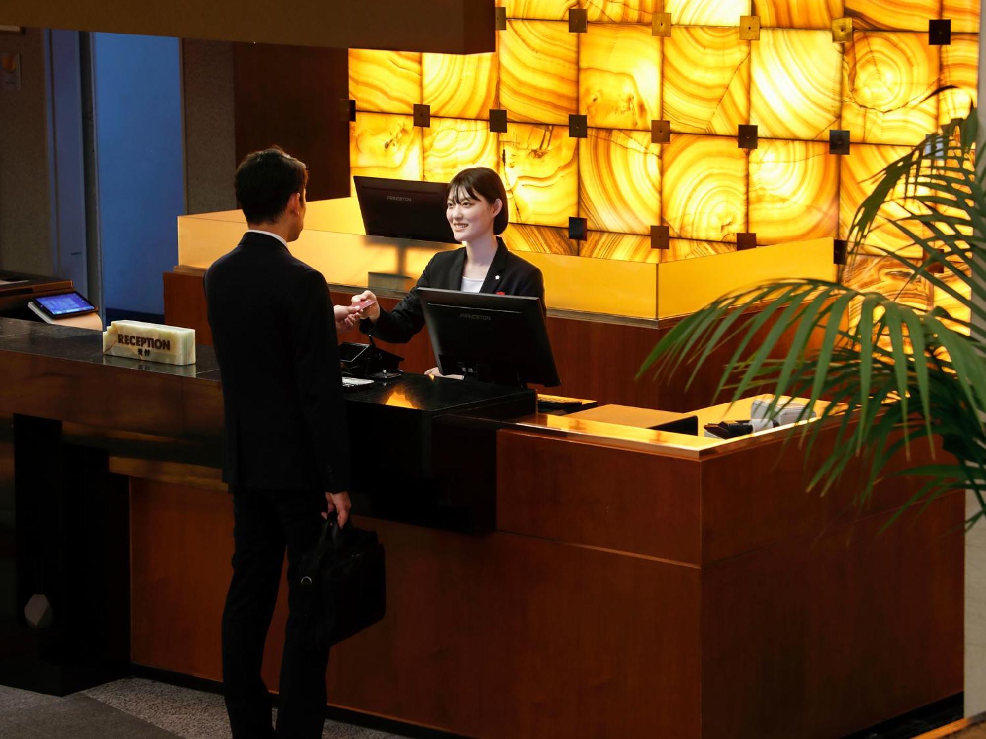 Premier Hotel -Tsubaki- Sapporo Exterior photo A hotel receptionist at work